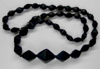 Perlenkette aus schwarz mattierten Doppelpyramiden und ein paar schwarzen Rocailles, in Gablonz hergestellt.
 Zum Kriegsende 1945 versteckt, wurden diese Ketten jetzt nach über 60 Jahren wiederentdeckt. Im Orginalzustand belassen.